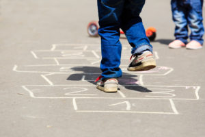 kids playing hopscotch on playground outdoors, children outdoor activities